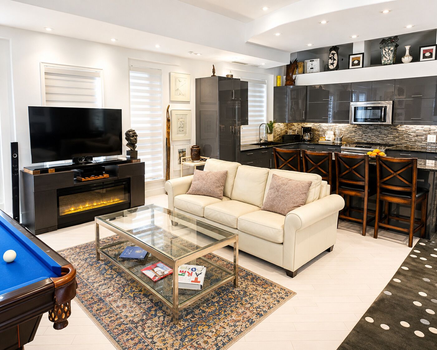 A modern living room with a sofa, coffee table, and a pool table.