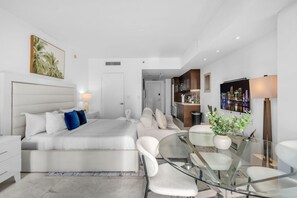 Una habitación de hotel moderna con una cama, una mesa de vidrio y un sofá.