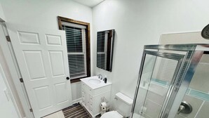 Un baño con inodoro, lavamanos y ducha.