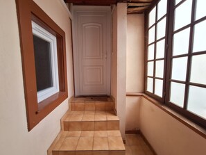 A narrow hallway with a door, a window, and a set of stairs. - Little ingersheim near Colmar (Ingersheim)