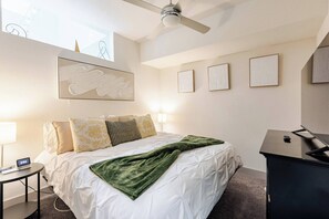 A hotel room with a bed, a desk, a chair, a ceiling fan, and framed artwork on the wall. - Penthouse Paradise Riverwalk Views Rooftop View (San Antonio)