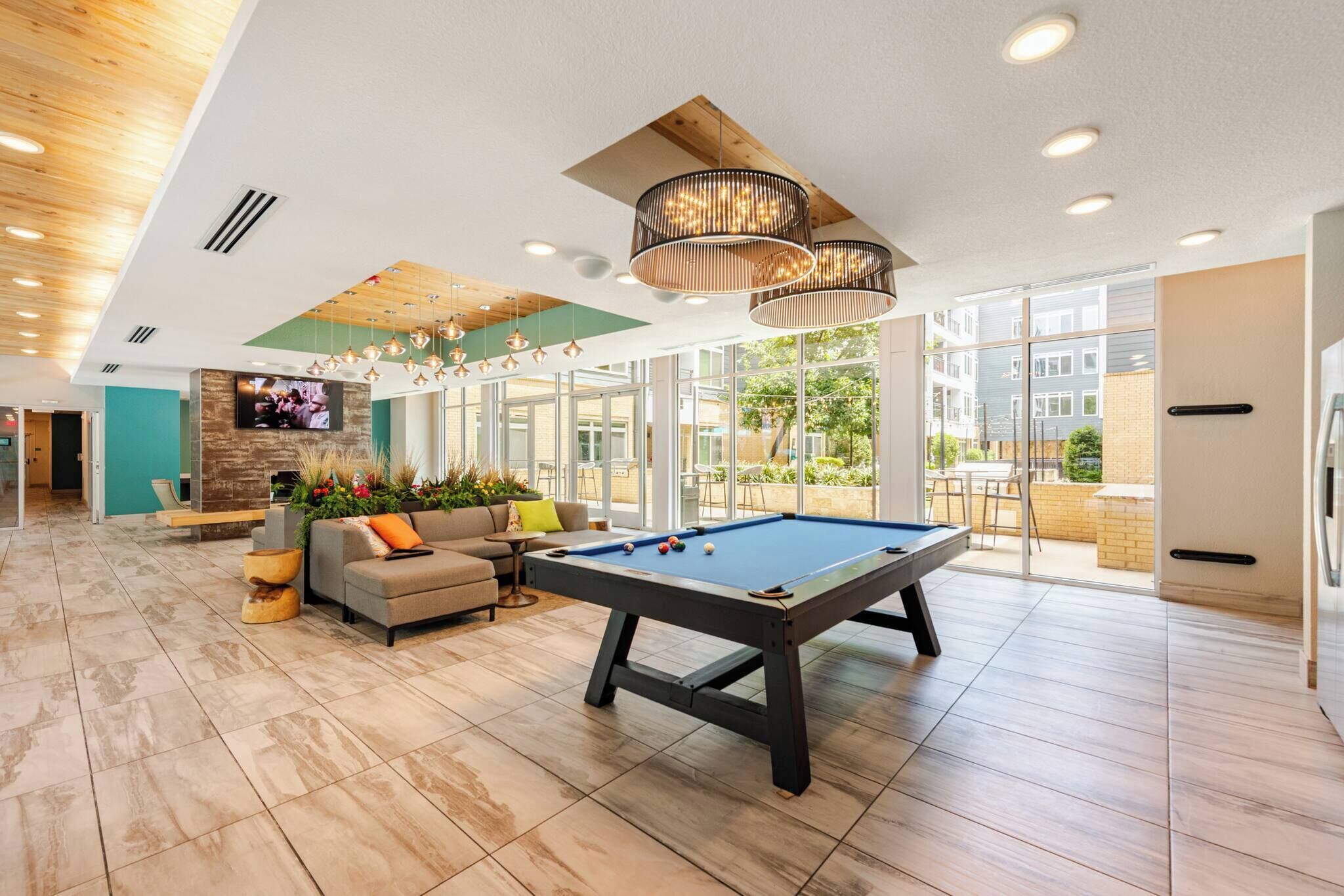 A spacious indoor area with a pool table, a sofa, and a television.