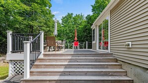 A set of wooden steps leading to a porch with outdoor furniture and a covered area. - Cozy 2-bedroom cottage in charming Frye Island-Four minute walk to the beach (Frye Island)