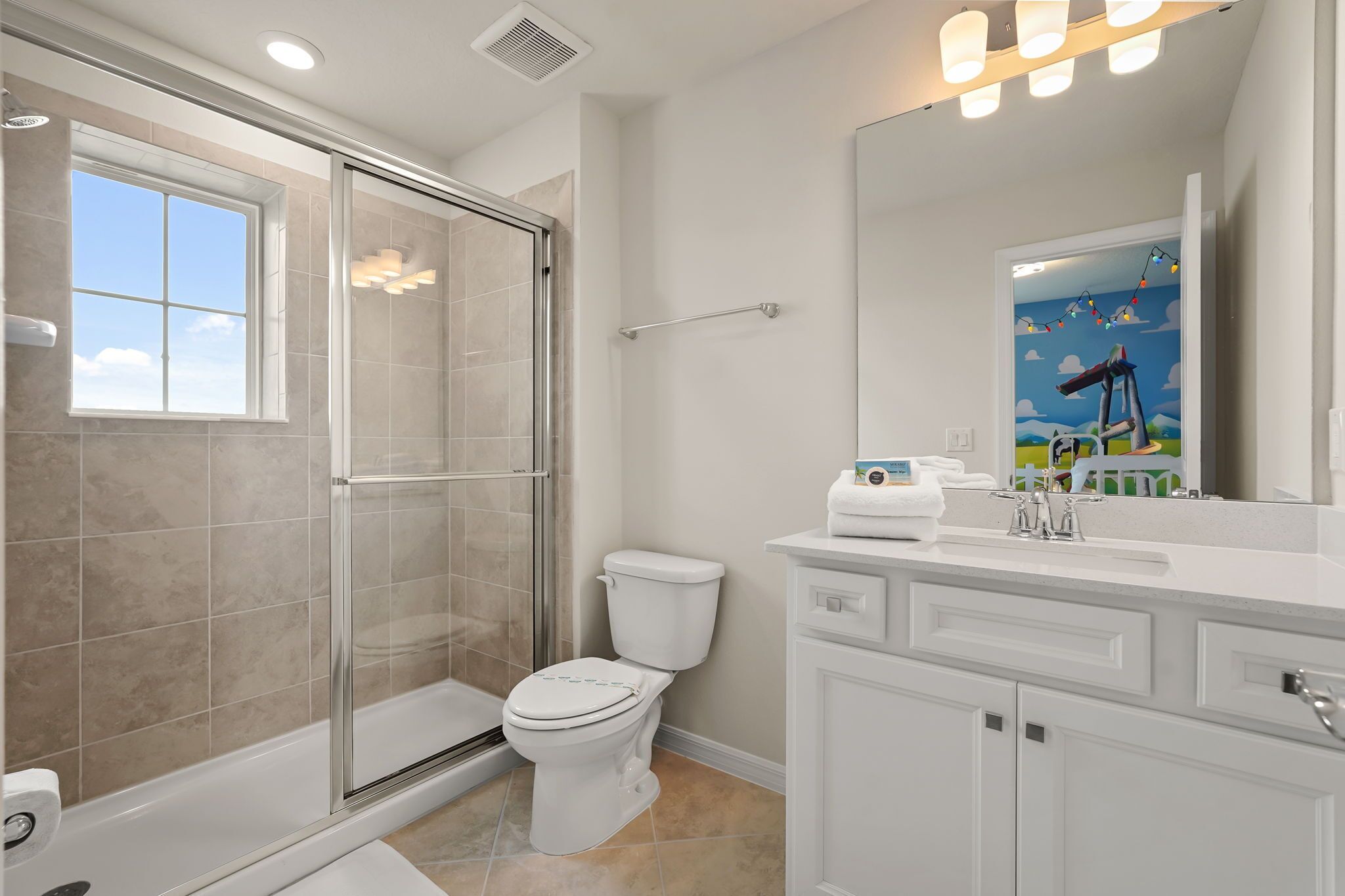 A bathroom with a glass-enclosed shower, a toilet, and a sink with a mirror.