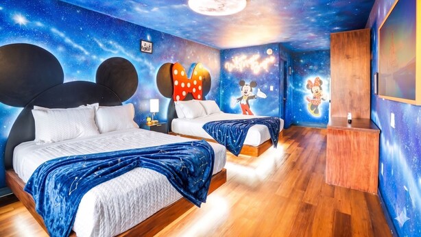 A bedroom with a starry ceiling, two beds with Mickey Mouse headboards, and a mural of Mickey and Minnie Mouse. - The Mickey and Minnie studio w/ pool & parking (Kissimmee)