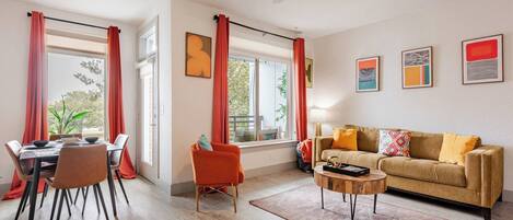 Un salon moderne comprenant un canapé, une table basse et un coin repas avec des chaises et une table.