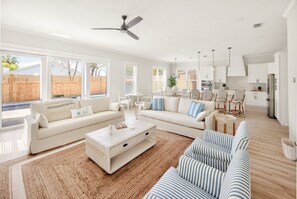 Ein geräumiges Wohnzimmer mit einer großen Eckcouch, einem Couchtisch und Blick auf den Garten.