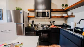 Une cuisine moderne équipée d’un réfrigérateur en acier inoxydable, d’un four à micro-ondes, d’une cuisinière et d’un évier.
