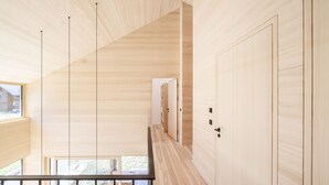 Un interno moderno con pannelli in legno, una scala e una vista dalla finestra.