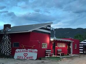 Un bâtiment rouge avec une enseigne sur laquelle on peut lire « SALIDACIRCUS, BIENVENUE » et une antenne parabolique.