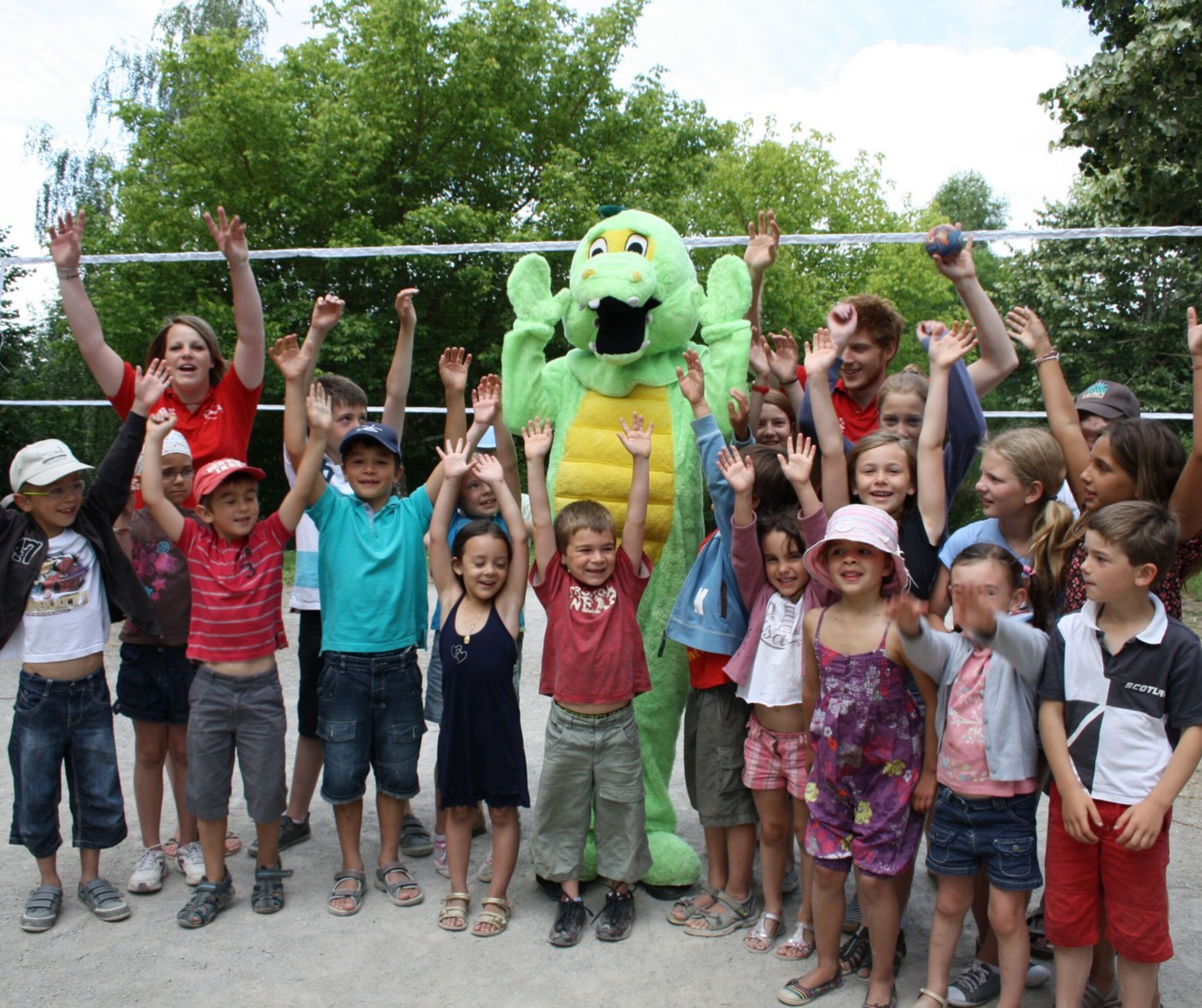 Un grupo de niños y un adulto con un disfraz de mascota en un parque.