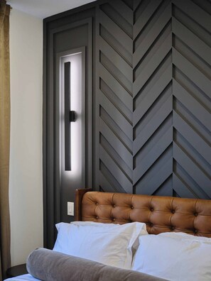 A hotel room with a bed, a door, and a wall with a chevron pattern.