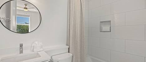 Ein Badezimmer mit Waschbecken, Toilette und Duschvorhang.
