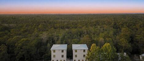 A two-story building with a symmetrical facade, surrounded by dense forest.