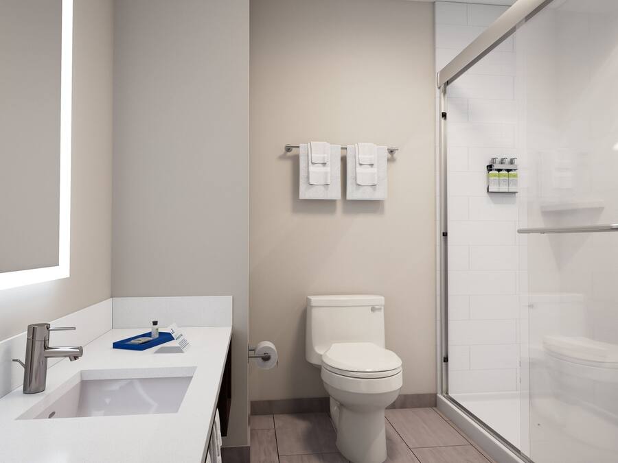 A modern bathroom with a white sink, toilet, and shower.