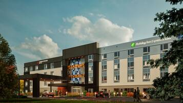 A hotel with a modern design, featuring a mix of brick and glass facades, and a prominent Holiday Inn Express & Suites sign.