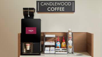 Eine Kaffeemaschine mit dem Aufdruck 'COSTA' und ein Schild mit der Aufschrift 'CANDLEWOOD COFFEE'.