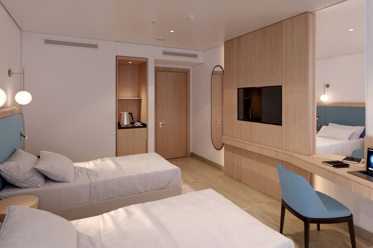 A hotel room with two beds, a desk, a TV, and a minibar.