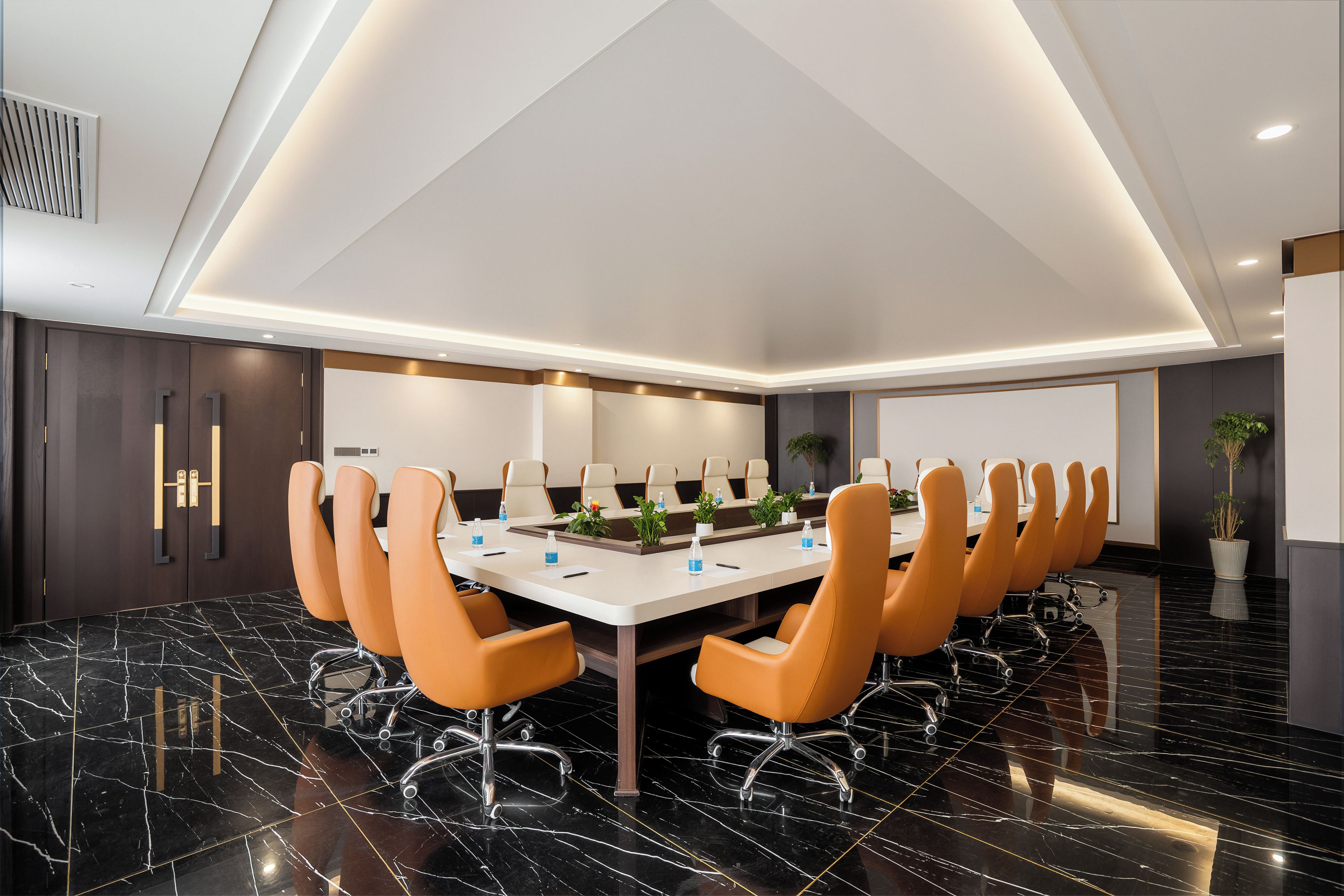 Una sala de conferencias con una larga mesa, varias sillas y un diseño de techo moderno.
