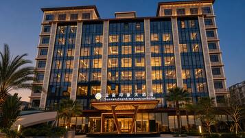 A multi-story hotel with a modern facade, large windows, and a well-lit entrance.