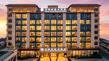 A hotel with a modern facade, multiple floors, and a central entrance.