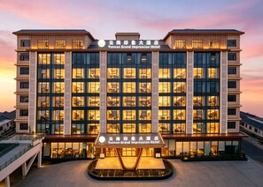 Un hotel con fachada moderna, varios pisos y una entrada central.