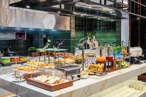 A buffet setup with various food items and a coffee station.