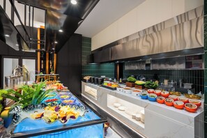 Una cocina moderna con un montaje tipo bufé, que incluye distintas estaciones de comida y un centro de mesa decorativo.