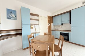 Una cocina moderna con armarios azul claro, una mesa de comedor de madera y un reloj en la pared.
