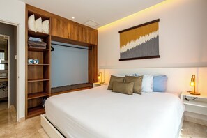 Ein Schlafzimmer mit einem großen Bett, einem Holzschrank, einem Nachttisch mit Lampe und einem Wandbild.