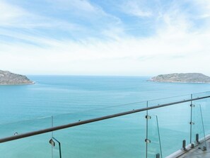 A coastal view from a balcony with a railing, clear sky, and calm sea. - Oceanfront Views of the Three Islands (Mazatlan)