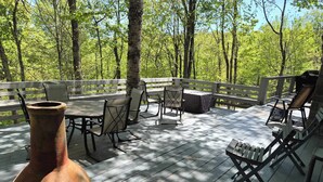 A wooden deck with outdoor furniture, a large vase, and a view of a forest. - Private homes Beech Mountain! (Beech Mountain)
