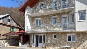 A two-story building with a stone facade, a balcony with metal railings, and a small outdoor seating area. - Gorgeous home in Buzim (Buzim)