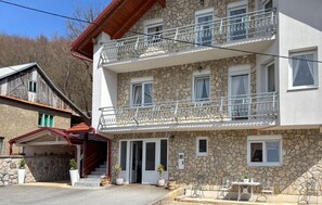 A two-story building with a stone facade, a balcony with metal railings, and a small outdoor seating area. - Gorgeous home in Buzim (Buzim)