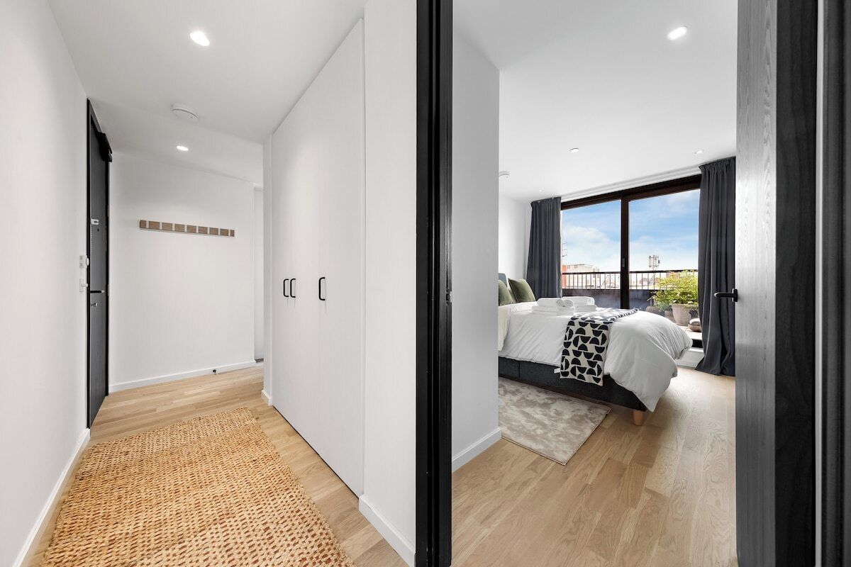 Une chambre moderne avec une grande fenêtre, un lit et une vue sur la ville.