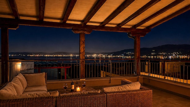 A balcony with wicker furniture, a candle, and a bottle of wine. - Gorgeous home in Splitska (Splitska)