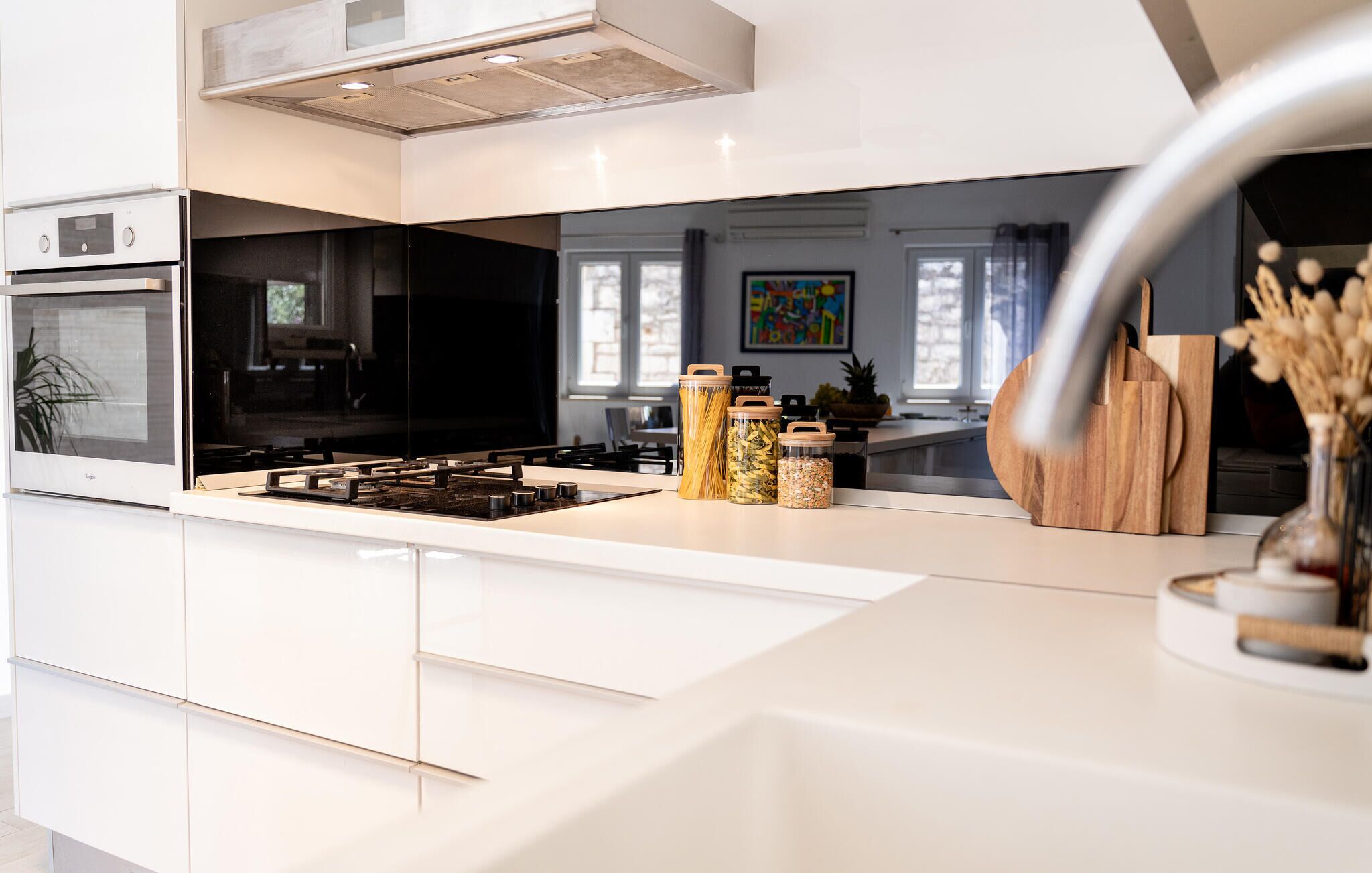 Une cuisine moderne dotée d’un îlot central, d’un four encastré et d’appareils électroménagers en acier inoxydable.