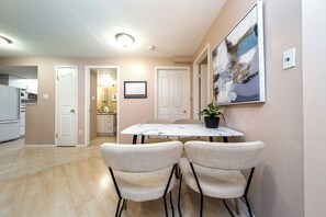 A dining area with a marble table, four chairs, and a potted plant. - Cozy 2BR Suite In Lewis Estates Golf Course By Henday/Whitemud-Long Stay Suite! (Edmonton)