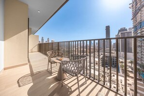 A balcony with a view of a cityscape, a table, and two chairs. - Free Housekeeping Visits During Your Stay - Stayshort - Modern 1 Bed Apartment in JVC That Sleeps 4 With Balcony (Dubai)