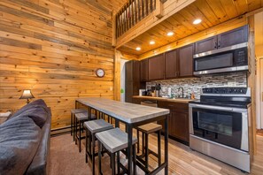 A wooden interior with a kitchen, a dining area with a table and stools, and a sofa. - Condo w/ Lock Off Near Granby Ranch, Golf, Fishing (Granby)