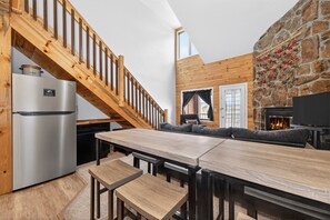 A modern kitchen with a built-in refrigerator, wooden staircase, and a stone wall with a fireplace. - Condo w/ Lock Off Near Granby Ranch, Golf, Fishing (Granby)