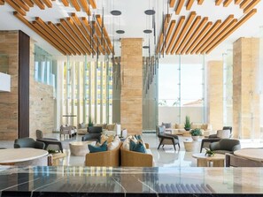 A modern lobby with a high ceiling, wooden slats, and a marble floor. - ¡Apartamento de lujo frente al mar en Mazatlán! (Mazatlan)