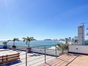 Una terrazza sul tetto con vista sul mare e sullo skyline della città.