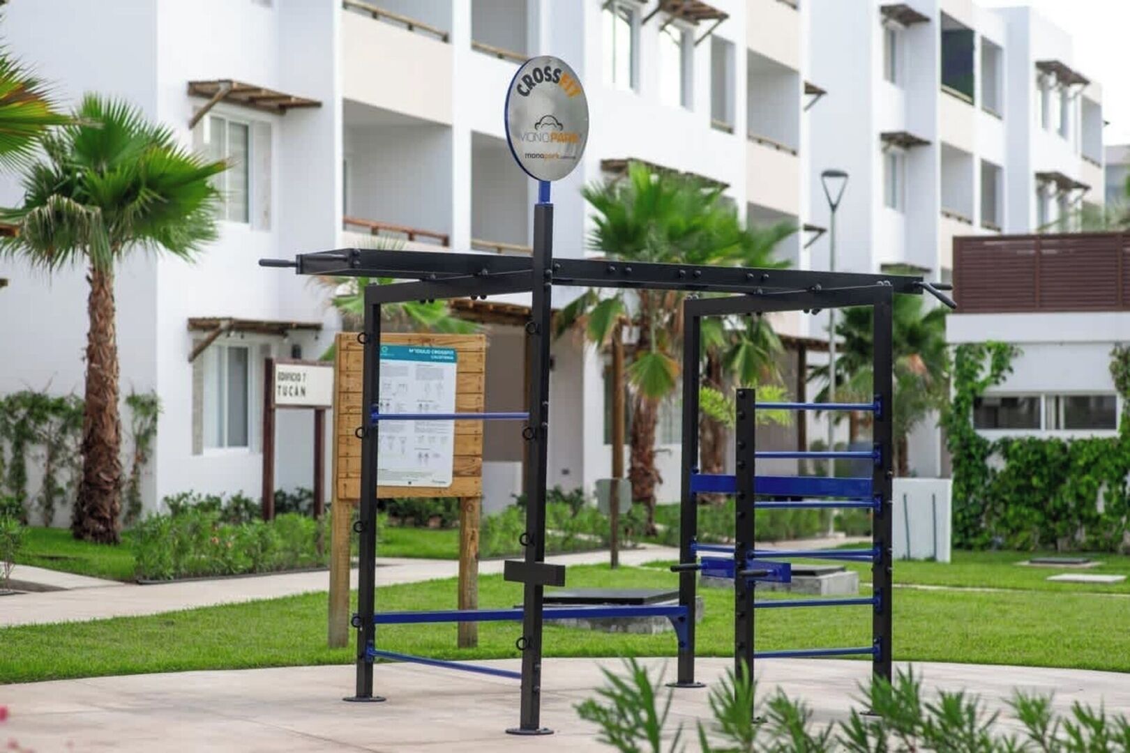 Een fitnessruimte met trainingsapparatuur, een bord voor een zebrapad en een gebouw op de achtergrond.