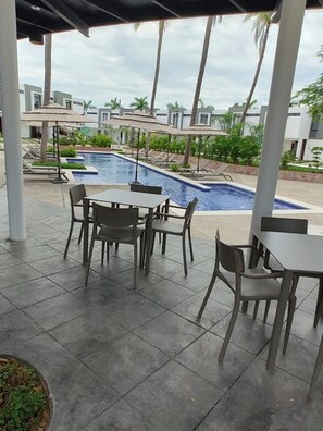 A covered outdoor area with a pool, lounge chairs, and umbrellas. - House in Mezcales near Vallarta (Mezcales)