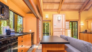 A modern kitchen with a large island, wooden cabinets, and a built-in microwave.