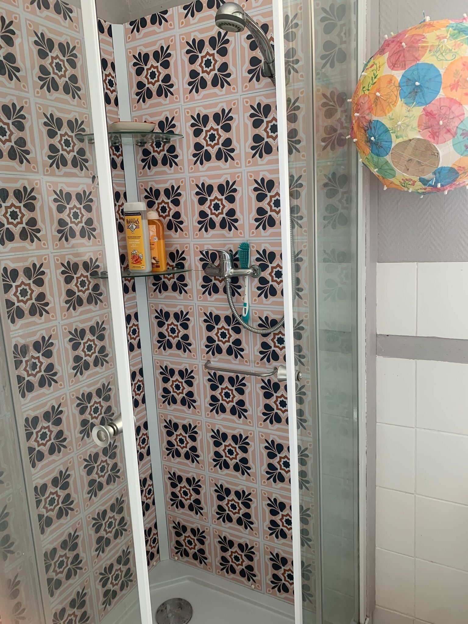 Chuveiro com porta de vidro, chuveiro e mangueira.