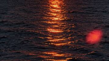 A sunset over the ocean with sunlight reflecting on the water.
