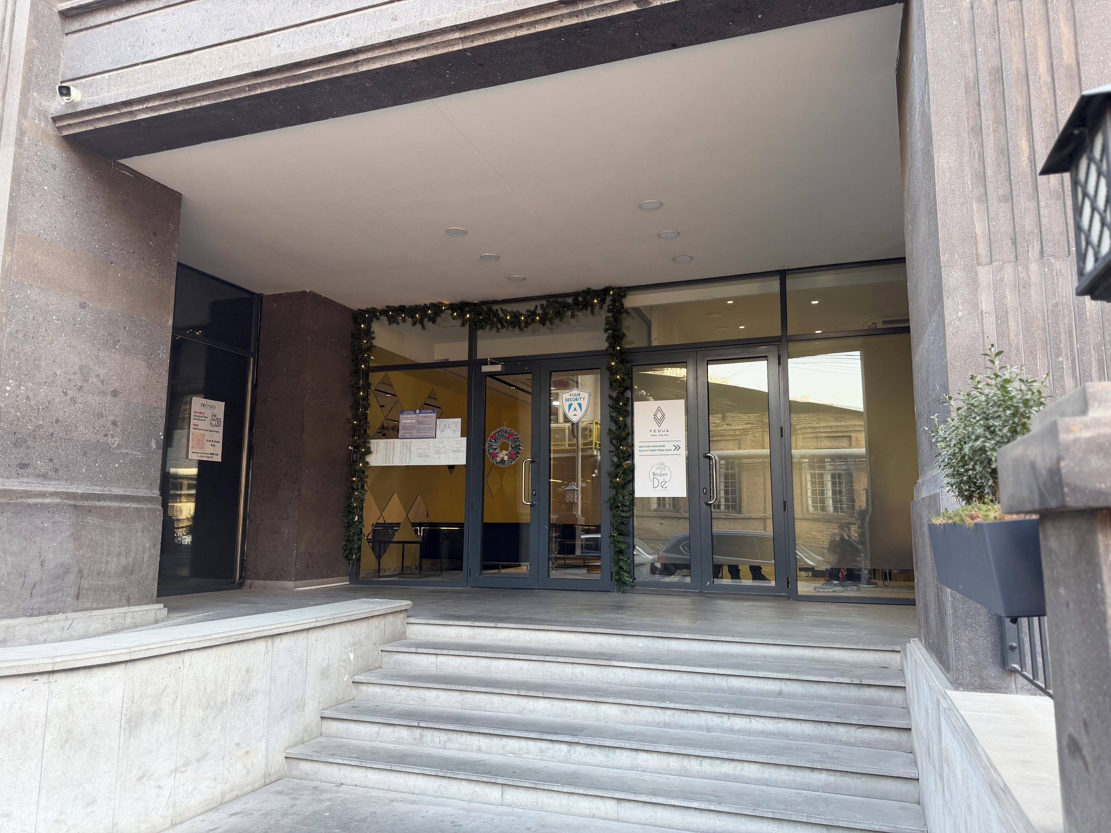 A hotel entrance with a glass door, steps leading up to it, and a sign indicating a four-star rating.