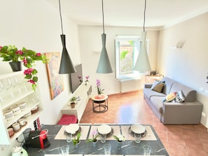 Ein modernes Wohnzimmer mit Essbereich, einer Couch und einem Fernseher.
